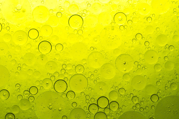 желтые пузырьки на воде, масло рассеяно по водной текстуре пузырьков
 - Фото, изображение