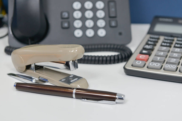 Équipement de bureau avec téléphone IP, stylo, agrafeuse et calculatrice
 - Photo, image