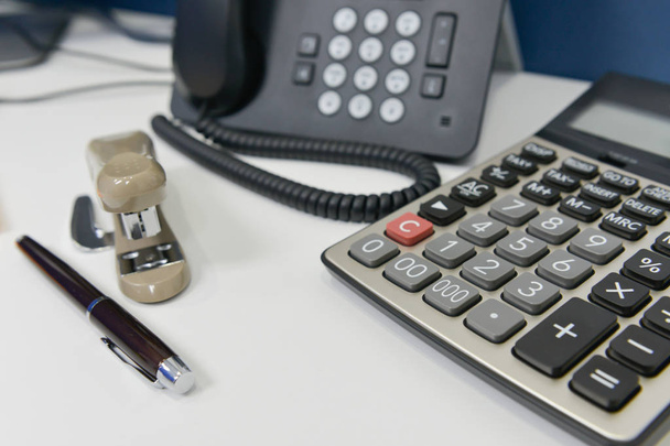 Office equipment with IP Phone, pen, stapler and calculator - Foto, Bild