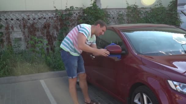 セルフ サービス、洗車に彼の車を洗う若い白人男。車のお手入れ. - 映像、動画