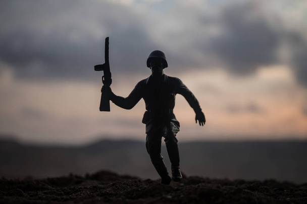 戦争の概念。軍隊は戦争の霧空の背景、夕暮れ時の曇りスカイライン次世界大戦兵士のシルエットに戦闘シーンをシルエットします。兵士が戦車から脱出しよう - 写真・画像