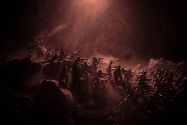 Concepto de guerra. Siluetas militares peleando escena en el fondo del cielo niebla de guerra, Soldados de la Guerra Mundial Siluetas debajo del horizonte nublado Por la noche. Escena de ataque. Vehículos blindados. Enfoque selectivo. Decoración
 - Foto, Imagen