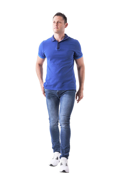 Front view of confident relaxed man walking towards camera and looking up with hand in pocket. Full body isolated on white background. - Φωτογραφία, εικόνα