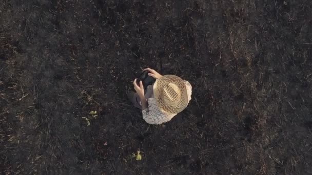 Pohled shora mužské zemědělce létající dron s dálkovým ovládáním v sklizené pšeničné strniště v letní západ slunce - Záběry, video