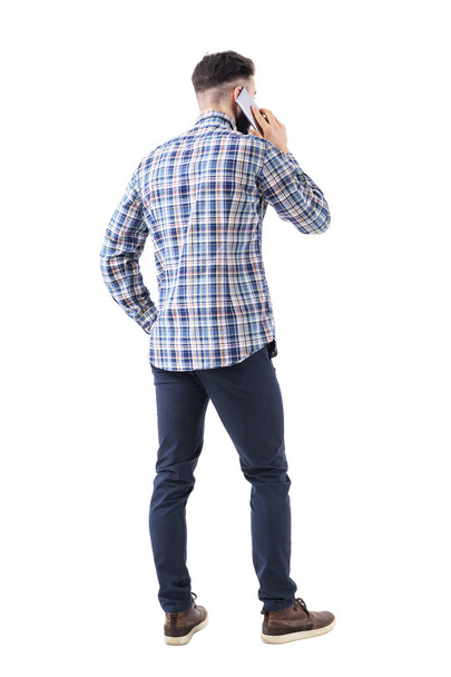 Nézet hátulról fiatal smart casual üzleti ember beszél-a cellphone. Teljes test elszigetelt fehér background. - Fotó, kép