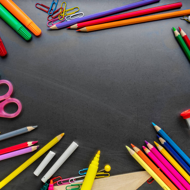 School supplies on blackboard background, top view. Back to school and Education concept.  Flat lay, copy space - Foto, Imagem
