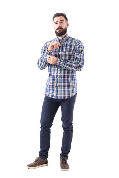 Homem barbudo jovem se vestir botões de botão manga e olhando com confiança para a câmera. Corpo inteiro isolado em fundo branco
. - Foto, Imagem