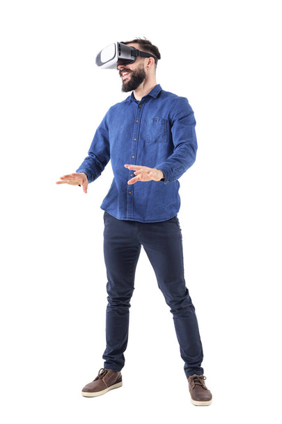 Excited young business man watching vr glasses laughing and gesturing with hands. Full body isolated on white background. - 写真・画像