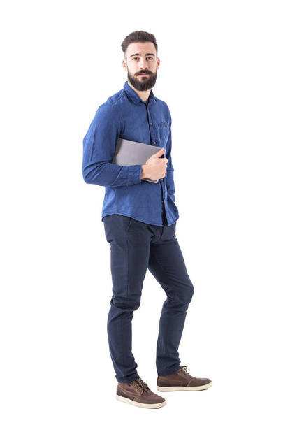 Confident successful young stylish bearded business man holding pad under arm looking at camera. Full body isolated on white background. - Photo, Image