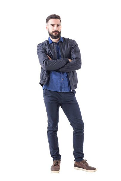 Charming young adult male in dark blue bomber jacket with crossed hands looking at camera. Full body isolated on white background. - Fotoğraf, Görsel