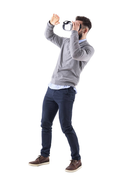 Amazed excited young adult man holding vr glasses and gesticulating with hand. Full body isolated on white studio background. - Valokuva, kuva