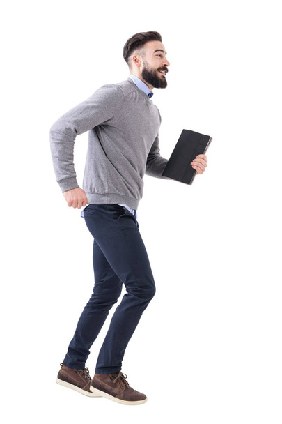 Drôle excité jeune homme d'affaires décontracté intelligent courir avec ordinateur portable dans les mains. Portrait intégral isolé sur fond de studio blanc
. - Photo, image