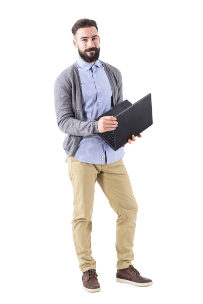 Happy smiling smart casual man holding laptop and looking at camera. Full body length portrait isolated on white studio background. - Foto, afbeelding