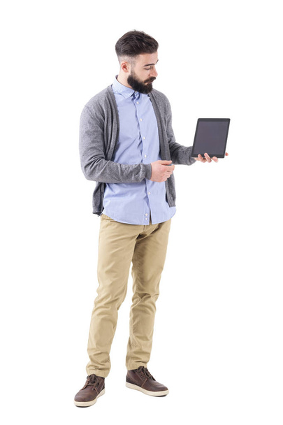 Stylish bearded businessman or teacher holding and looking at blank tablet computer. Full body length portrait isolated on white studio background. - Foto, Imagem