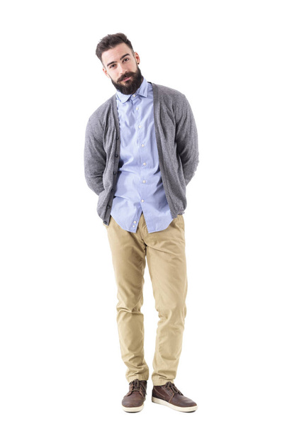 Cool relaxed smart casual guy in cardigan with hands behind leaning on side. Full body length portrait isolated on white studio background. - Foto, Imagen