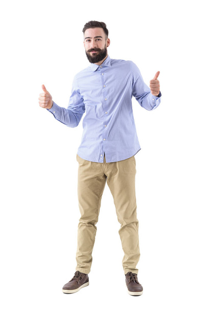 Happy excited young bearded man showing thumbs up and smile at camera. Full body length portrait isolated on white studio background. - Zdjęcie, obraz