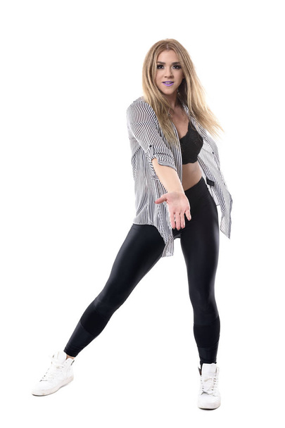 Young blonde attractive female jazz dancer moving and swinging arms looking at camera. Full body length portrait isolated on white studio background. - Fotó, kép