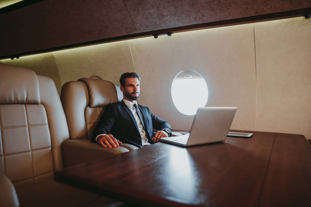Businessman flying on his private jet - Foto, Bild