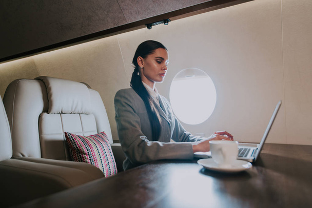 Επιχειρήσεων γυναίκα ταξιδεύουν και να εργάζονται για το ιδιωτικό αεριωθούμενο αεροπλάνο - Φωτογραφία, εικόνα