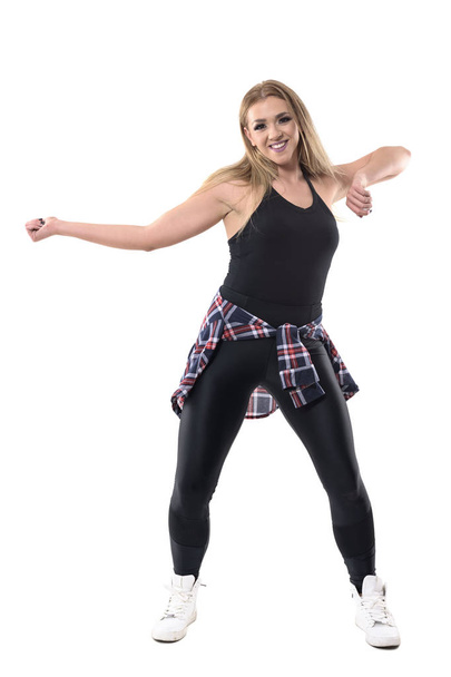 Młoda energiczna kobieta wesoły taniec jazz dance aerobik trening. Portret długość całego ciała na białym tle na tle białego studia. - Zdjęcie, obraz