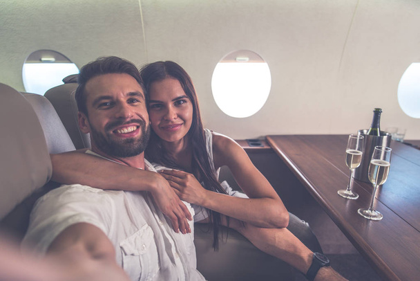 Couple on vacation, flying on their private jet - Фото, изображение