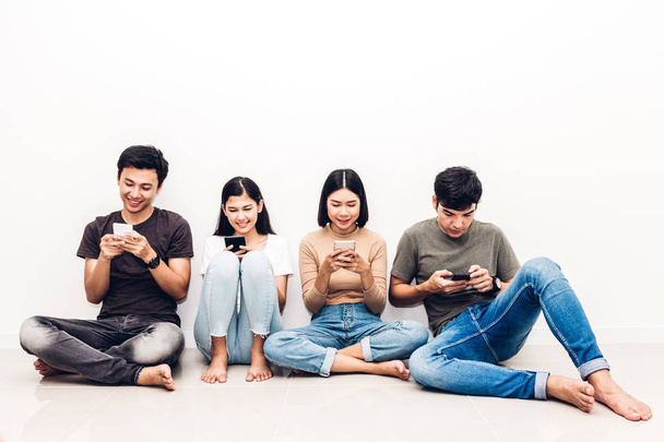 Ryhmä ystävä istuu rentoutua käyttää teknologiaa yhdessä älypuhelimen tarkistaa sosiaalisia sovelluksia vastaan kopioi tilaa taustalla.Viestintä käsite
 - Valokuva, kuva
