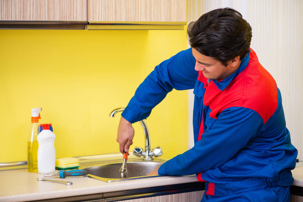 Сантехник ремонтирует кран на кухне - Фото, изображение