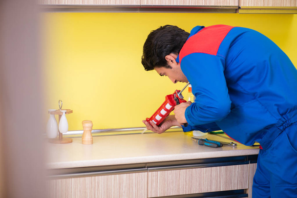 reparador trabajando en la cocina  - Foto, Imagen