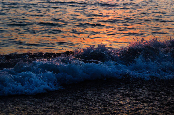 Sea waves roll to the shore at sunset - Fotografie, Obrázek