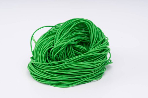 Мотузка, зелена гумова мотузка. красиво скручена мотузка на білому тлі
. - Фото, зображення