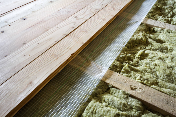 Installazione di nuovo pavimento di assi naturali in legno e isolamento lana minerale per l'isolamento e mantenere il calore. Tecnologie moderne, calda casa confortevole e concetto di isolamento ecologico. - Foto, immagini