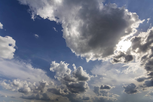 Fantástica vista panorámica de nubes hinchadas blancas brillantes iluminadas por el sol que se extiende contra el cielo azul profundo del verano que se mueve con el viento. Belleza y poder de la naturaleza, meteorología y concepto de cambio climático
. - Foto, imagen