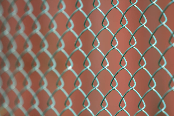 Közelkép az elszigetelt festett egyszerű geometriai fekete vas fém drót lánc láncszem kerítés eon sötét piros háttér. Kerítés, a védelem és a kamra fogalmát. - Fotó, kép