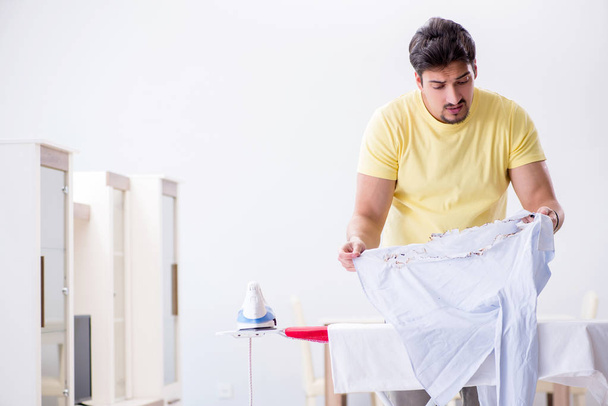 Handsome man husband doing clothing ironing at home - Foto, Imagen