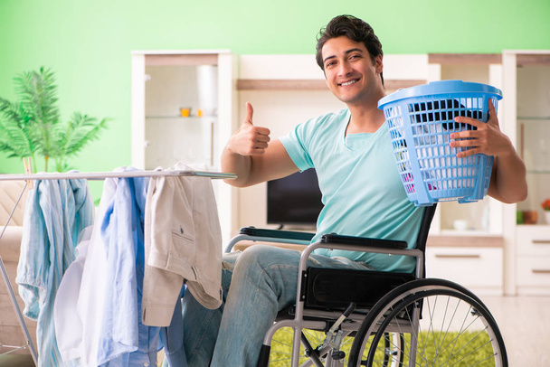 Инвалид на инвалидной коляске стирает белье - Фото, изображение