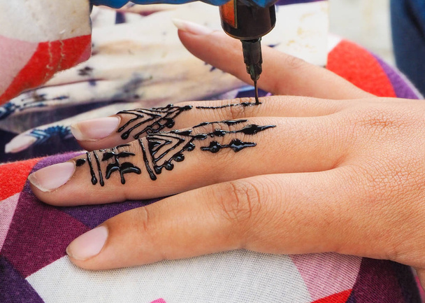 Henna tattoos being put on girls hand in Morocco - Photo, Image