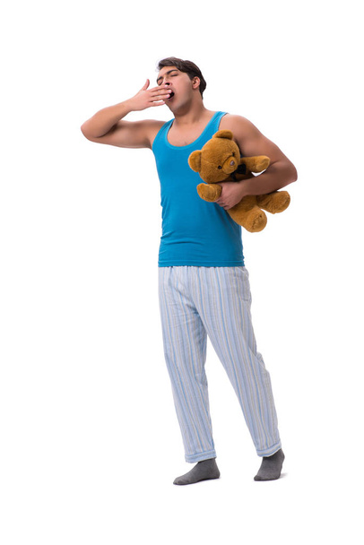 Mladý muž v pyžamu s hračka zvíře izolovaných na bílém poza - Fotografie, Obrázek