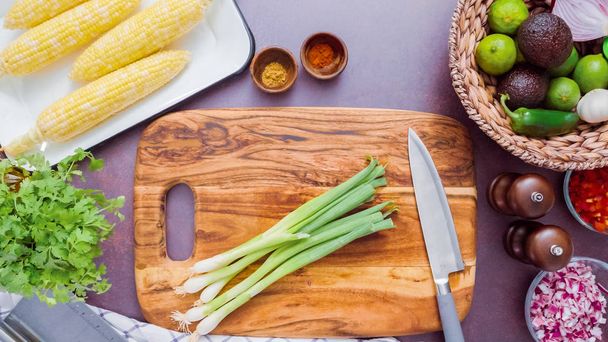 Step by step. Slicing green onions on a wood cutting board. - Foto, Imagen