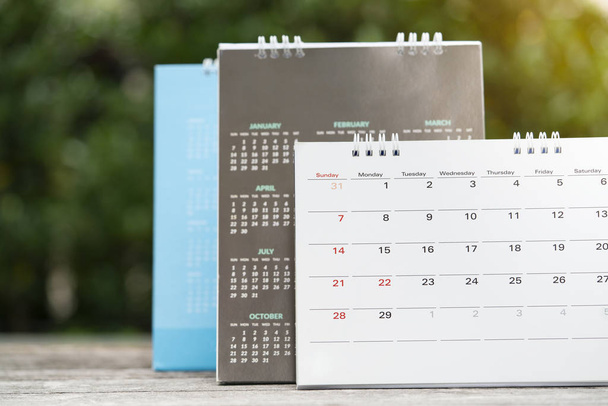 Az asztalon lévő naptár közelítése, üzleti megbeszélés vagy utazástervezés tervezése - Fotó, kép