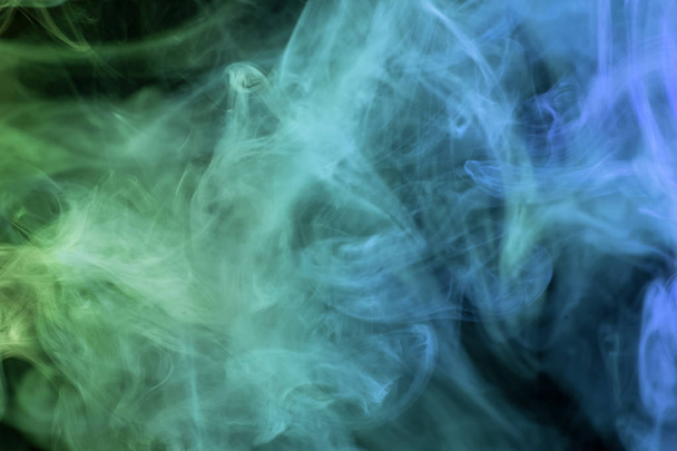 Siyah bir yalıtılmış zemin üzerine mavi ve yeşil renklerin yoğun çok renkli duman. Duman vap arka plan - Fotoğraf, Görsel
