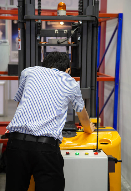 El trabajador opera la plataforma eléctrica que levanta la plataforma de la plataforma al almacenamiento
 - Foto, Imagen