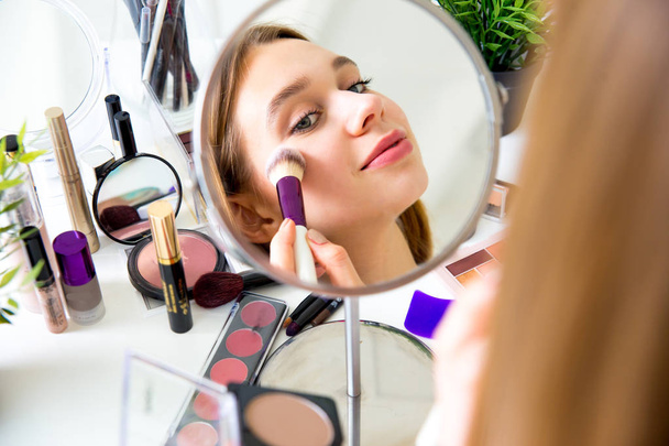 A portrait of woman with makeup brushes near face - Photo, Image