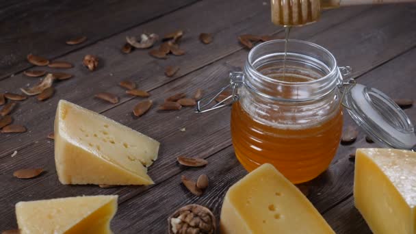Miel y queso. Servicio de mesa de restaurante. Queso duro con nueces sobre fondo de madera
 - Metraje, vídeo