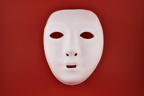 プラスチックの白い顔マスク ストック画像。赤の背景に白いマスク。プラスチック人間マスク - 写真・画像