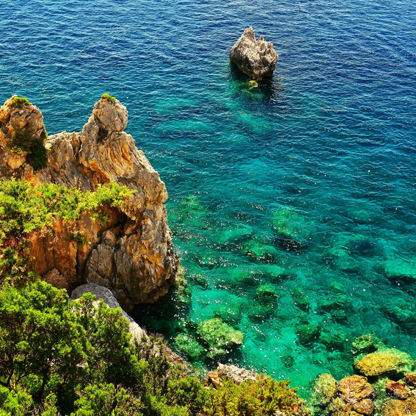 Gyönyörű tengerpart és a hajók. Tiszta tenger, egy öbölben. Utazás, nyaralás és turisztikai koncepció. Remek hely a nyaralás és a medence. Paleokastritsa, Korfu, Görögország. - Fotó, kép
