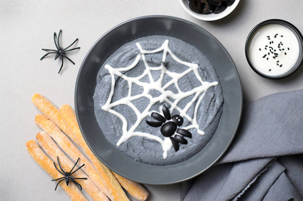 Black Hummus Halloween Dip Decorated with Cobweb and Spider, Halloween Spooky Party Treat - Fotó, kép