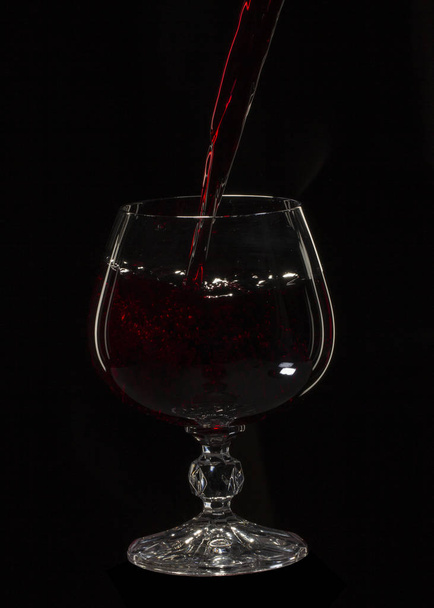 Verre nature morte image Un verre de vin rouge dans un verre sur un fond noir gros plan
 - Photo, image