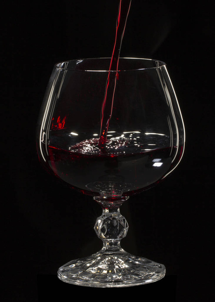 Glass still life image A glass of red wine in a glass on a black background close up - Valokuva, kuva