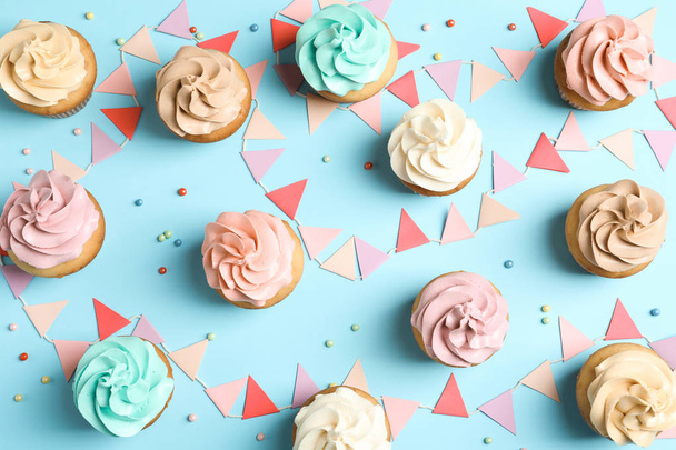 Flat lay composition with delicious birthday cupcakes on color background - Fotoğraf, Görsel