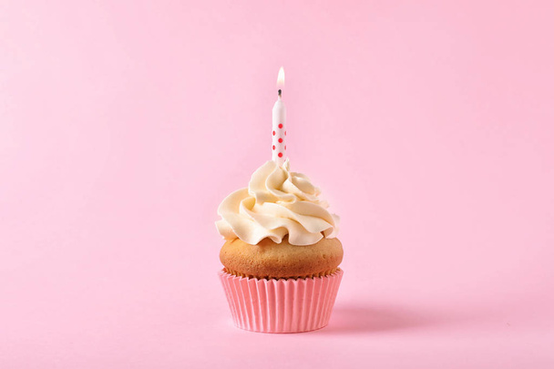Delicious birthday cupcake with candle on color background - Photo, image